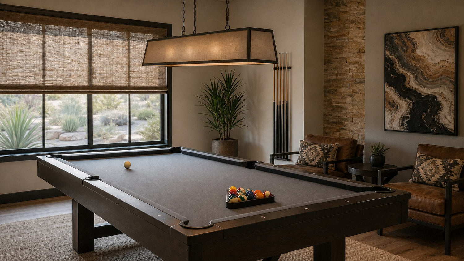 Pool table under centered lighting with woven window shades filtering afternoon glare