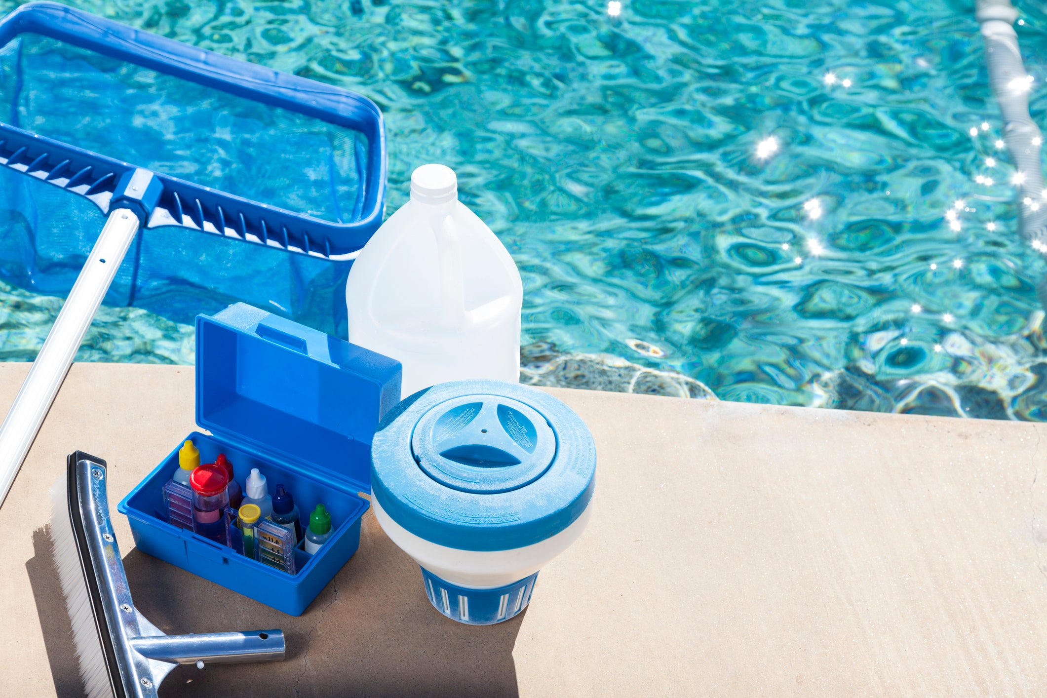 Pool maintenance kit on the edge of a swimming pool